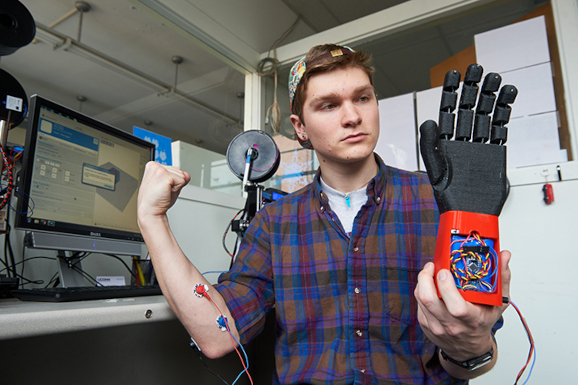 Stephen Hawes '17 (ENG) holds a 3D printed prosthetic hand on Feb. 1, 2016. (Peter Morenus for UConn)